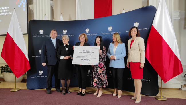 Na zdjęciu znajdują się przedstawiciele BCU, którzy odbierają symboliczny czek