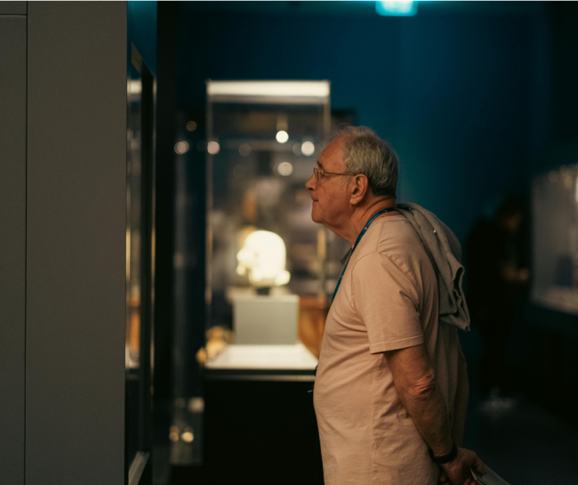 Straszy mężczyzna ogląda wystawę w muzeum 