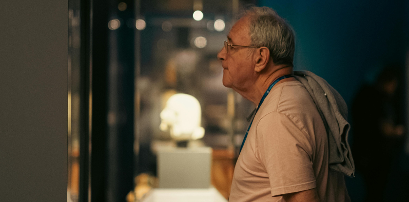 Straszy mężczyzna ogląda wystawę w muzeum 